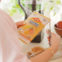 Person holding La Fe Pulp Mango package, ready to use in recipes for a taste of fresh Latin flavors.