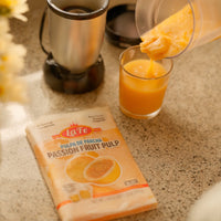 LA FE pulpa de parchá passion fruit pulp being poured into a glass, showcasing fresh Latin flavors.