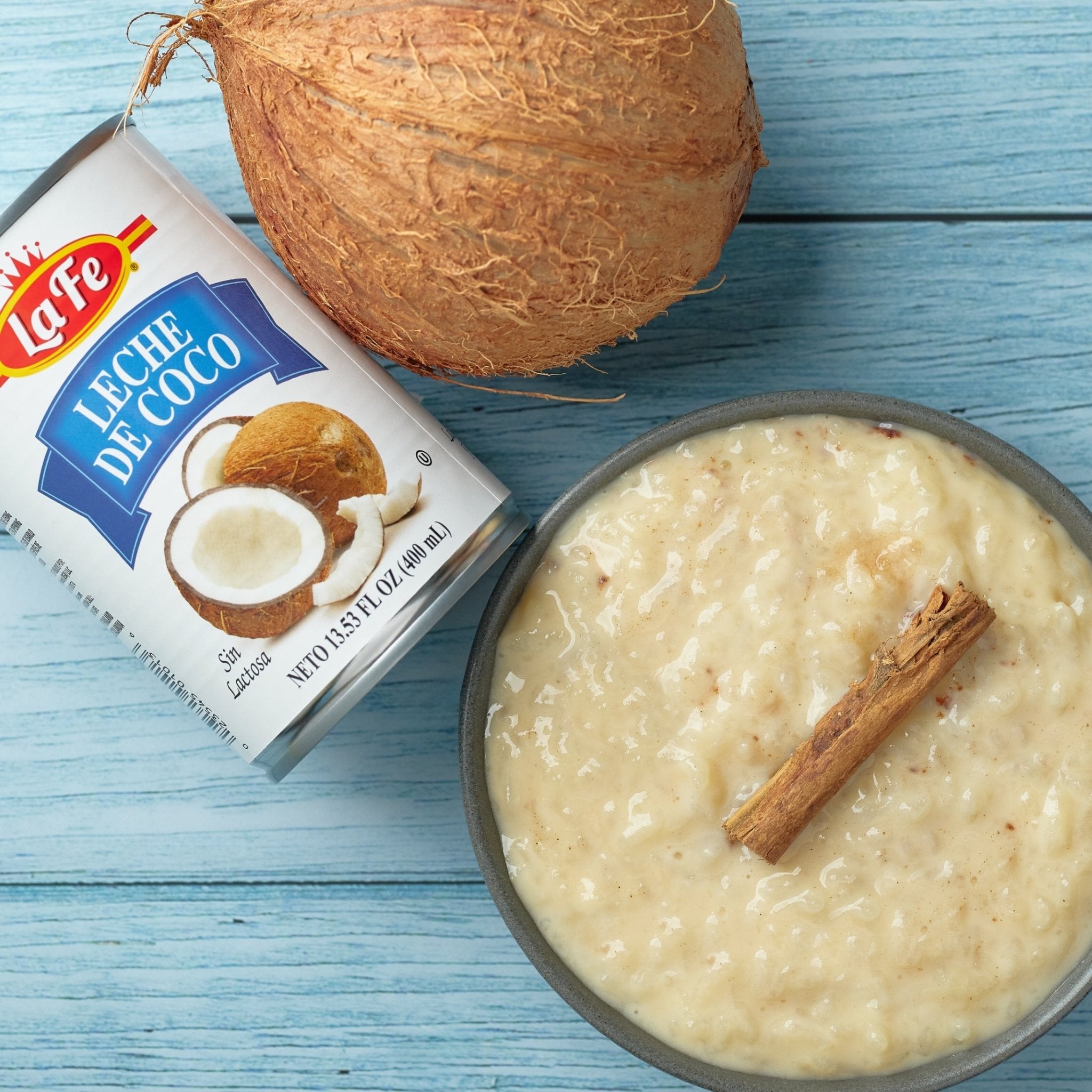 La Fe coconut milk can beside a bowl of creamy coconut rice topped with cinnamon, showcasing authentic Latin flavors.
