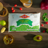 La Fe Baby Lima Beans package surrounded by fresh vegetables, a staple for authentic Latin food and healthy meals.