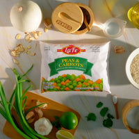 La Fe Peas & Carrots 12 oz pack with fresh vegetables on a kitchen counter, perfect for comida latina and tasty meals.
