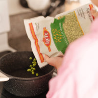 Pouring LA FE frozen pigeon peas into a pot, perfect for authentic Latin recipes and healthy meals.