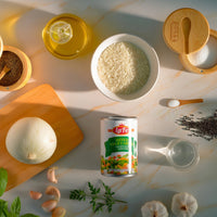 La Fe Veg Can Mixed-Vegetables among rice, spices, and oil, showcasing authentic Latin food preparation.