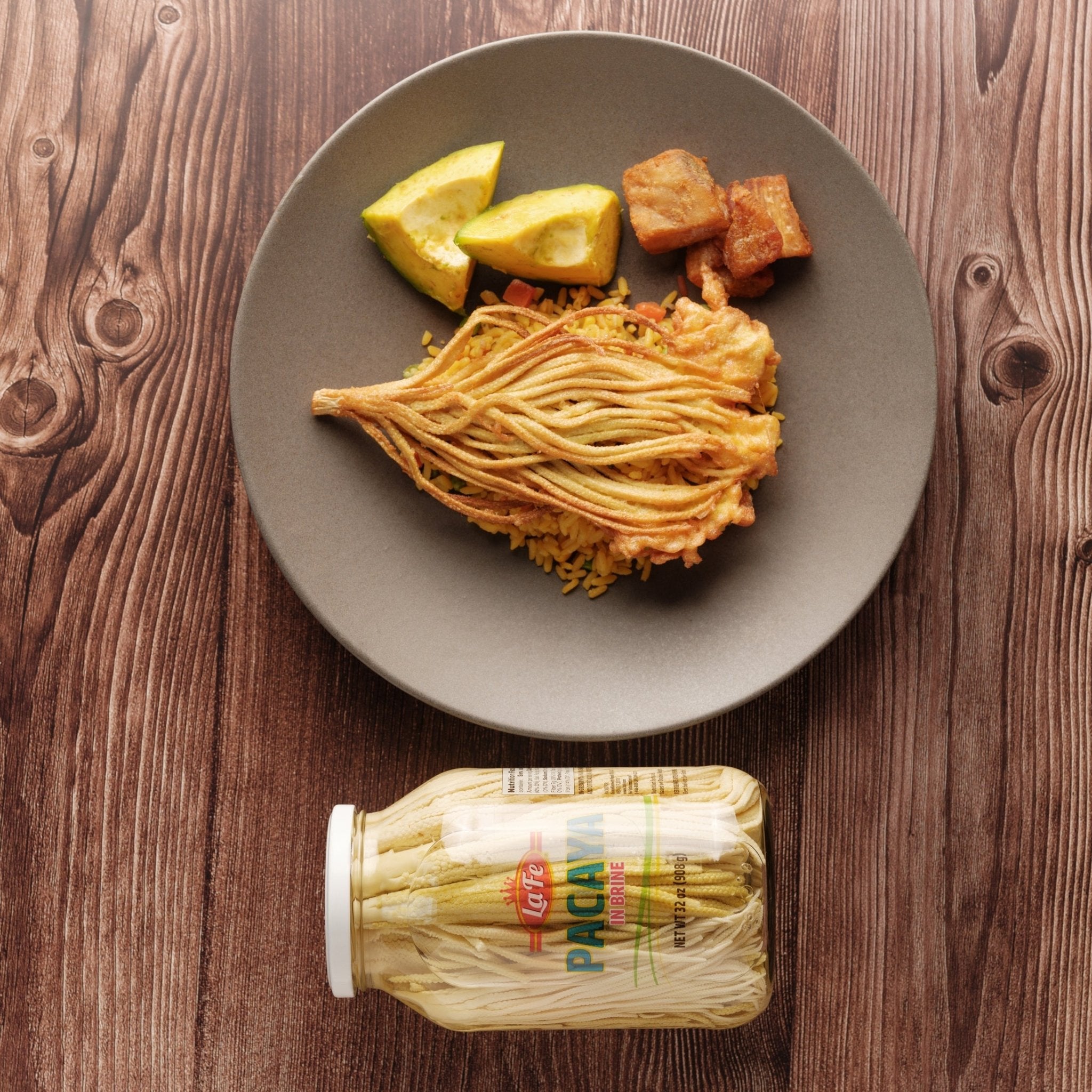 La Fe Conserva Pacaya served with rice and lime on a plate, showcasing quality Latin food for authentic meals.