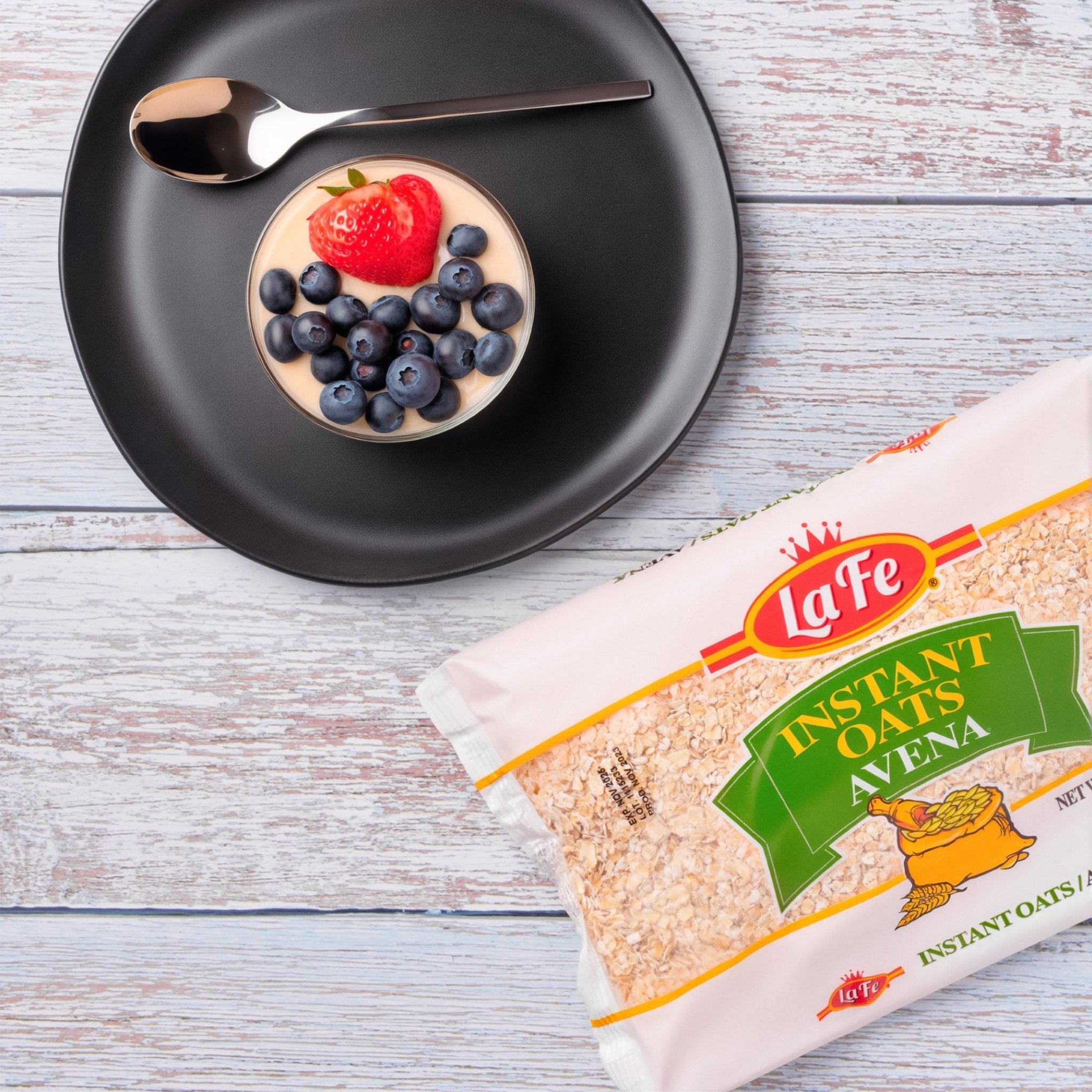 La Fe Quick Oats package next to a bowl of oats topped with blueberries and strawberry, showcasing quality Latin food.