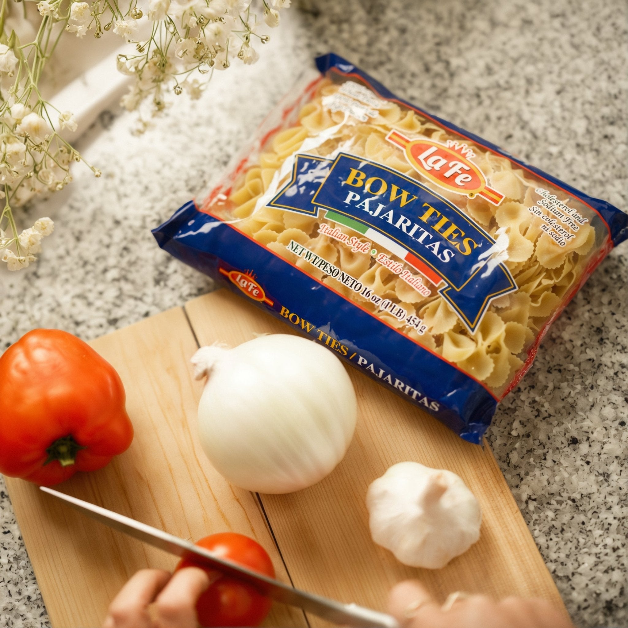 La Fe's Bow Tie Pasta with fresh vegetables on cutting board, perfect for authentic Latin dishes.