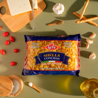 LA FE Pasta Shells packaged on a table with fresh ingredients, perfect for authentic Latin cooking and family meals.
