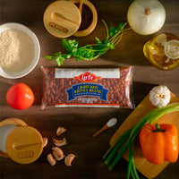 La Fe Light Red Kidney Beans surrounded by fresh vegetables and spices, ideal for authentic Latin cooking.