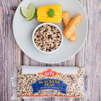 Plate of LA FE blackeye peas with corn, lime, and fried plantains, showcasing delicious Latin food products.