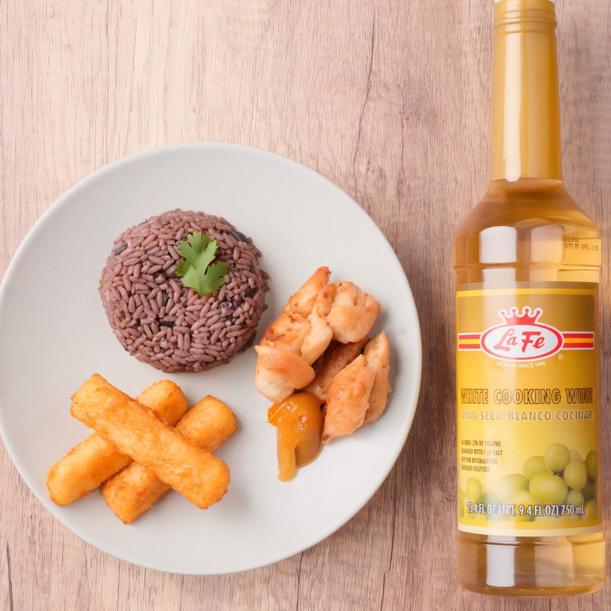 LA FE White Cooking Wine paired with delicious Latin food: rice, chicken, and fried plantains on a plate.