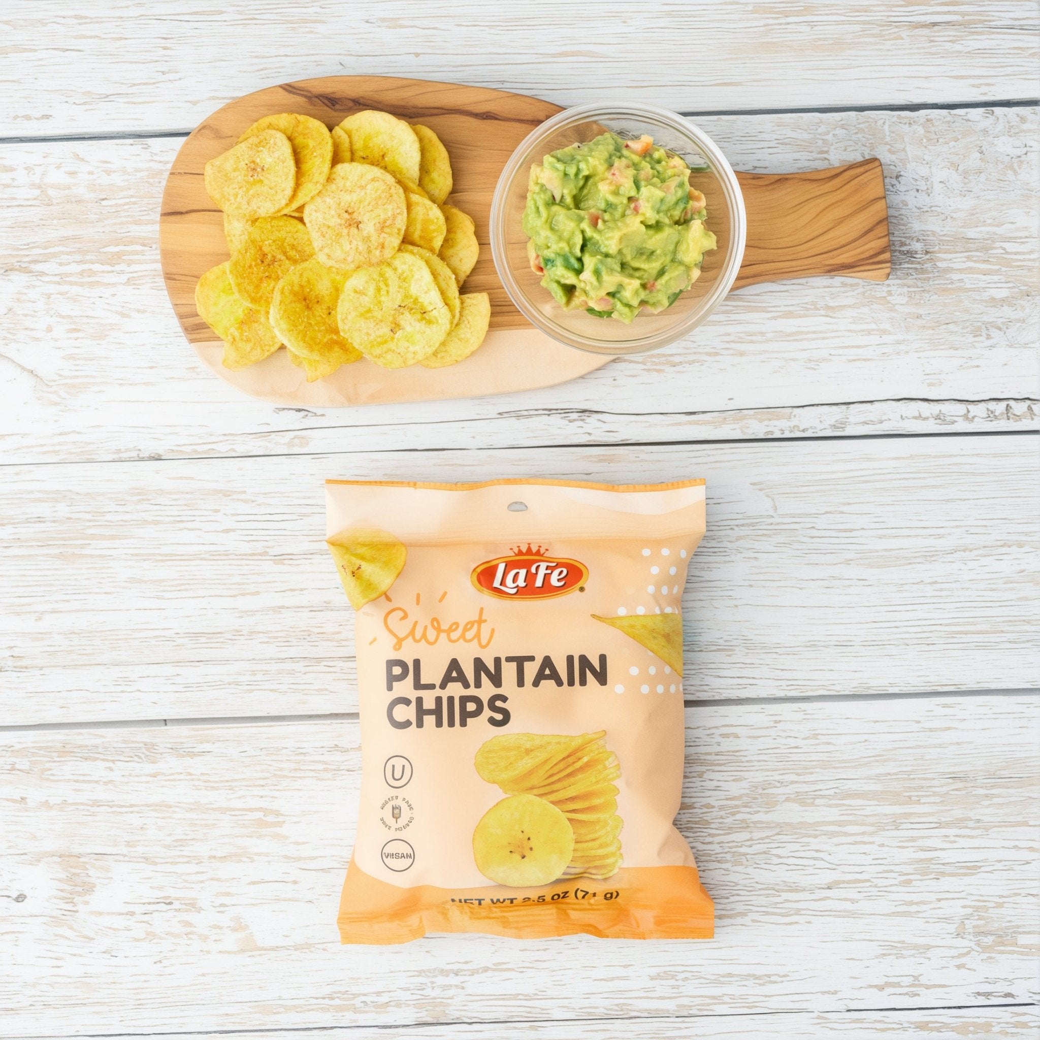 La Fe Sweet Plantain Chips snack with guacamole on a wooden board, perfect for enjoying authentic Latin flavors.