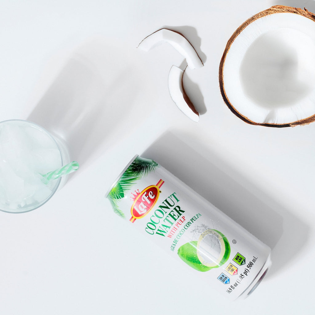 LA FE Drink Coconut Water can with a coconut half and a refreshing glass, perfect for healthy hydration.
