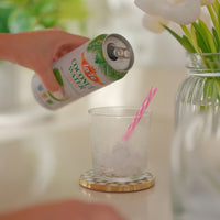 Pouring LA FE coconut water into a glass with ice, showcasing refreshing tropical flavors for healthy hydration.