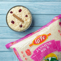 La Fe Jasmine Rice bag with creamy rice pudding topped with berries and cinnamon, representing quality Latin food.