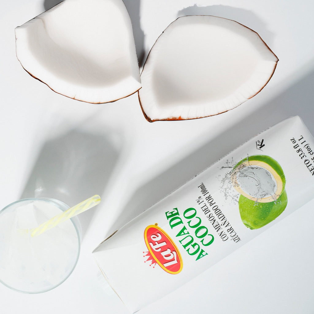 La Fe coconut water packaging with fresh coconut halves, a refreshing choice for tropical flavors and quality Latin drinks.